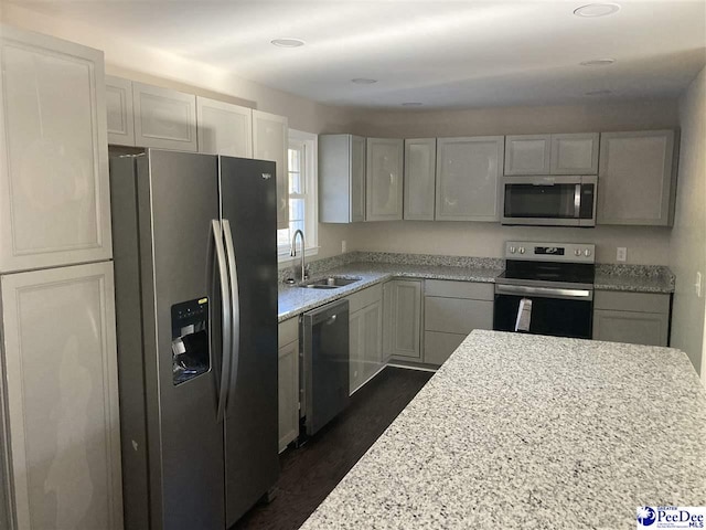 kitchen featuring light stone counters, sink, dark hardwood / wood-style floors, and appliances with stainless steel finishes