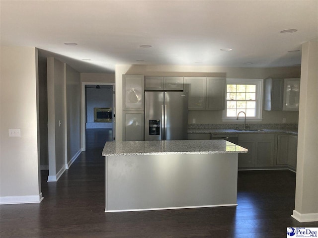 kitchen featuring a center island, sink, gray cabinetry, and stainless steel fridge with ice dispenser