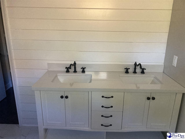 bathroom featuring vanity and wooden walls