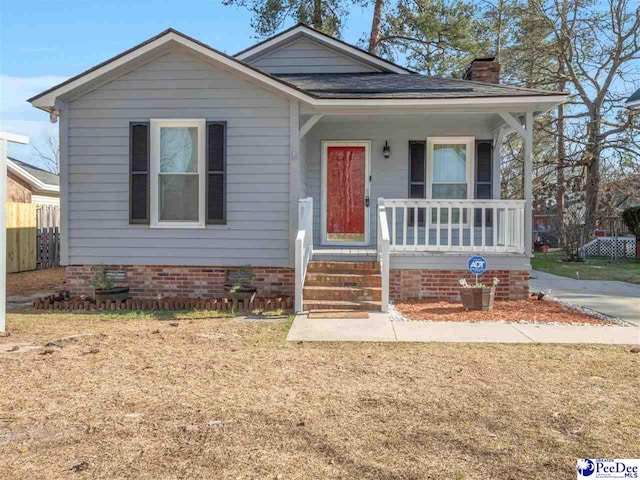 bungalow-style home with roof with shingles, a porch, crawl space, and a chimney