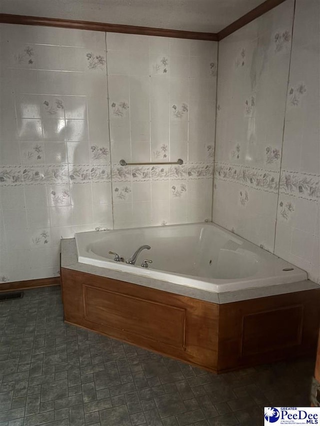 full bathroom featuring a garden tub, visible vents, and tile walls