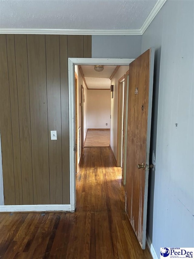 corridor with ornamental molding and dark wood-style flooring