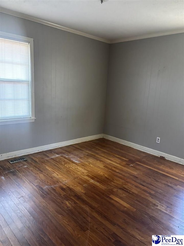 spare room featuring crown molding, visible vents, and dark wood-type flooring