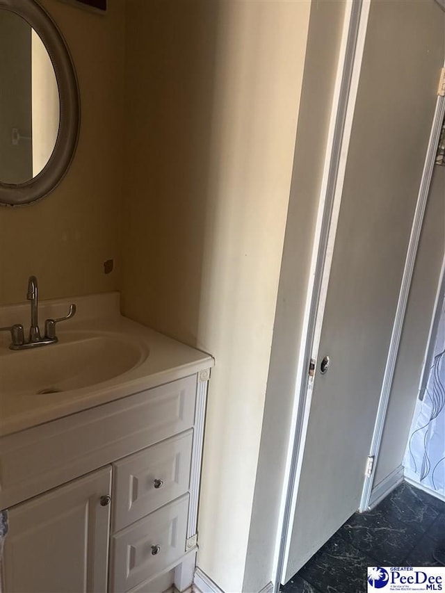 bathroom featuring marble finish floor and vanity