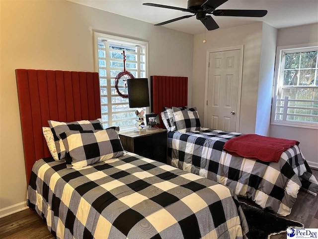 bedroom with dark hardwood / wood-style flooring and ceiling fan