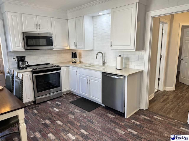 kitchen with white cabinetry, appliances with stainless steel finishes, sink, and decorative backsplash