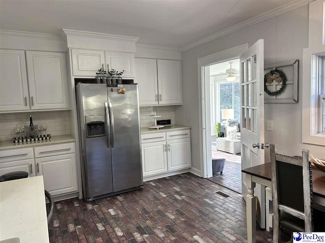 kitchen with white cabinetry, ornamental molding, backsplash, and stainless steel fridge with ice dispenser