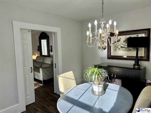 dining space with dark hardwood / wood-style flooring and a chandelier