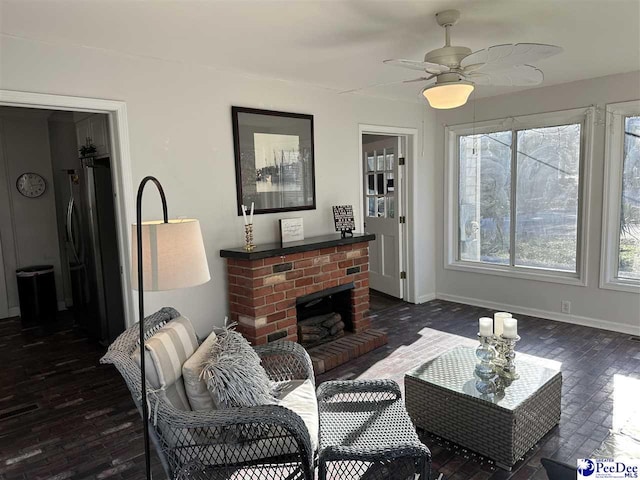 living room featuring a brick fireplace, dark hardwood / wood-style floors, and ceiling fan