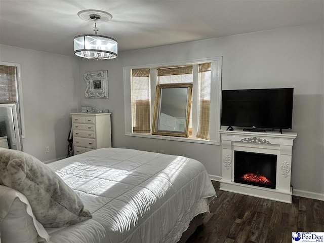 bedroom featuring dark wood-type flooring and a notable chandelier