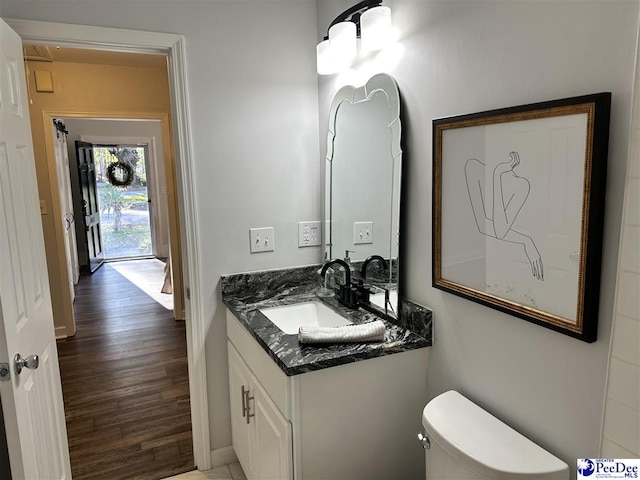 bathroom featuring vanity, toilet, and hardwood / wood-style floors