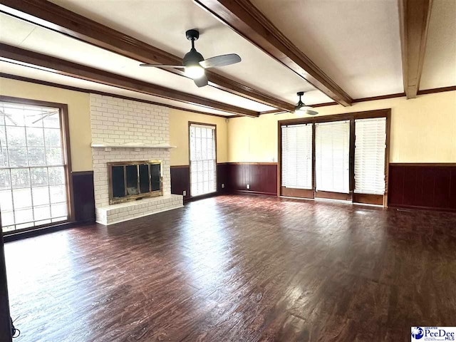 unfurnished living room featuring beam ceiling, plenty of natural light, and ceiling fan