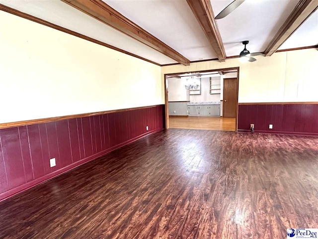 empty room featuring beamed ceiling, ceiling fan, and dark hardwood / wood-style flooring