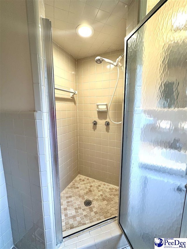 bathroom featuring tile walls and a shower with shower door