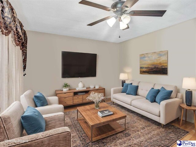 living room featuring dark hardwood / wood-style floors and ceiling fan