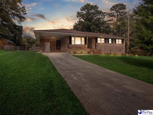 view of front of home with a carport and a yard