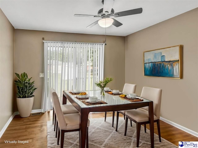 dining space with wood-type flooring and ceiling fan