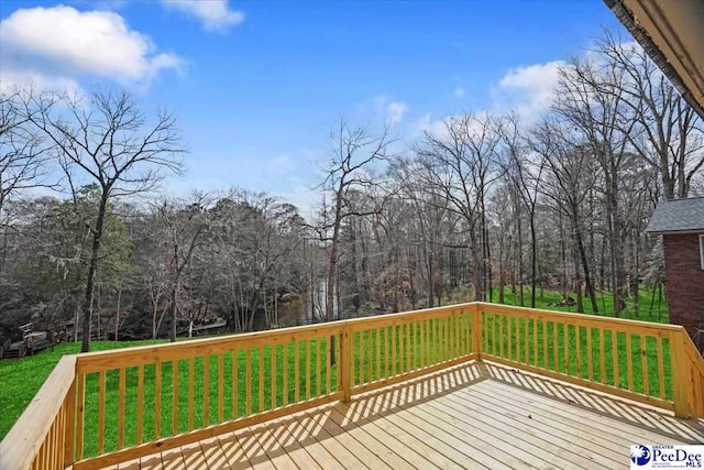 deck featuring a yard and a forest view