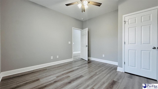 unfurnished bedroom featuring baseboards, a ceiling fan, and wood finished floors