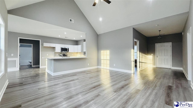 unfurnished living room featuring high vaulted ceiling, a sink, ceiling fan, light wood-style flooring, and visible vents