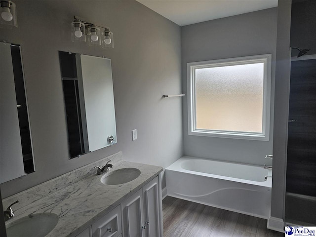 bathroom featuring hardwood / wood-style flooring, vanity, and a bathtub