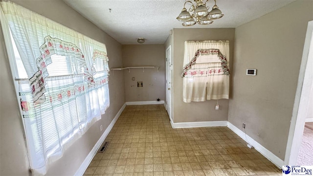 1416 Tradd Ct, Florence, SC 29506 - empty room with light floors, a chandelier, a textured ceiling, and baseboards