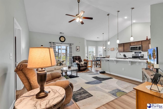 living room featuring sink, high vaulted ceiling, ceiling fan, and light wood-type flooring