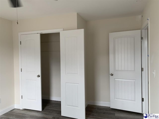 4978 E National Cemetery Rd, Florence, SC 29506 - unfurnished bedroom with dark wood finished floors, baseboards, and a closet