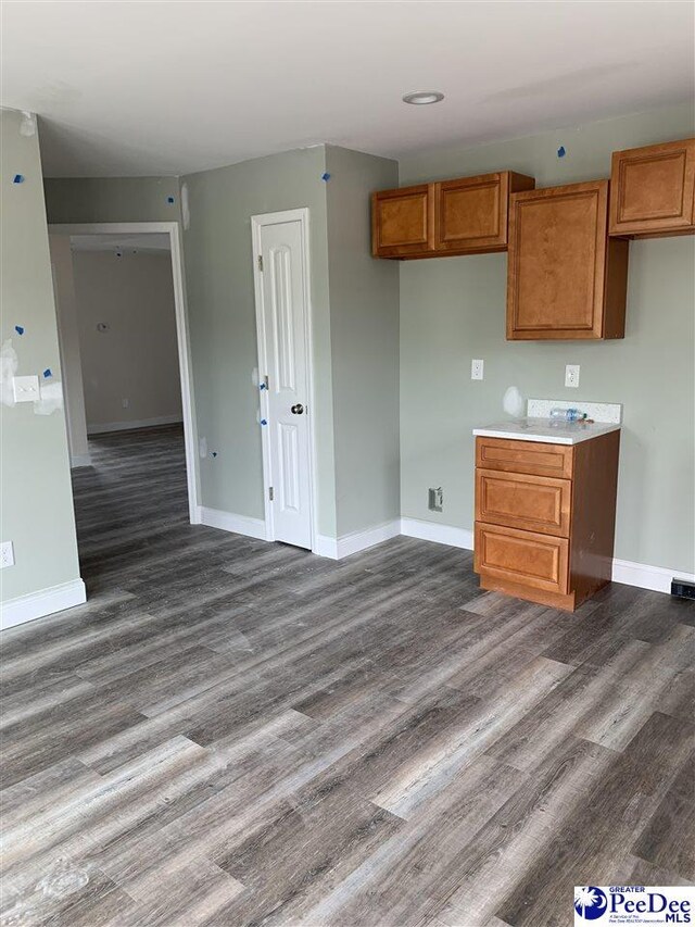 4978 E National Cemetery Rd, Florence, SC 29506 - kitchen featuring dark wood-style floors, brown cabinetry, and baseboards