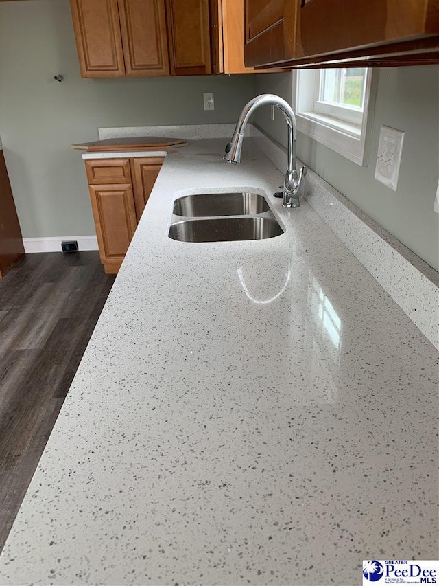 4978 E National Cemetery Rd, Florence, SC 29506 - kitchen featuring a sink, brown cabinets, baseboards, light stone counters, and dark wood finished floors