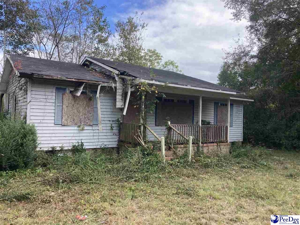 view of front facade with a front yard and covered porch