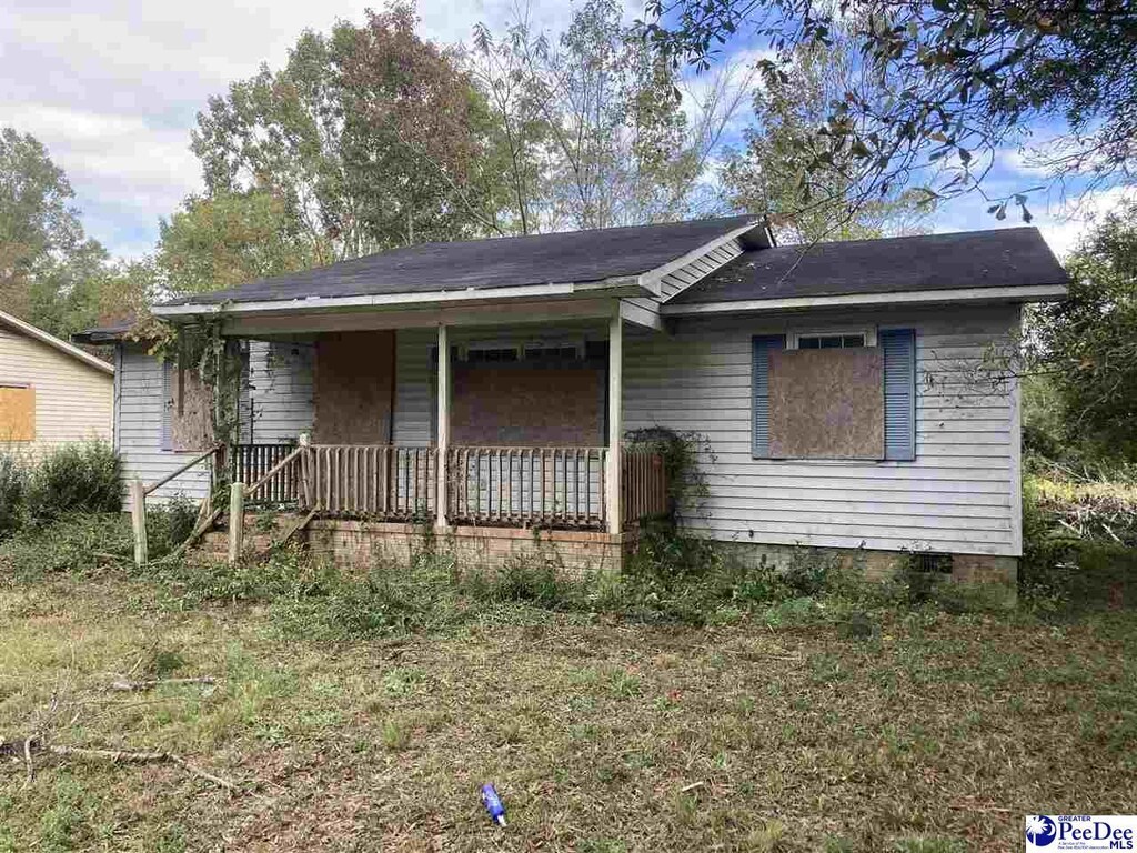 ranch-style home featuring a front lawn and a porch