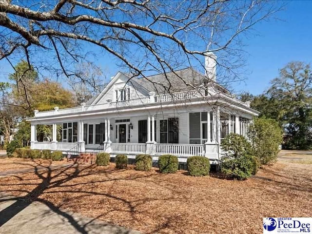 country-style home featuring a porch and a chimney