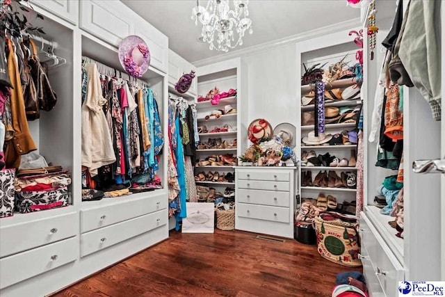 spacious closet featuring dark wood-style floors and a chandelier