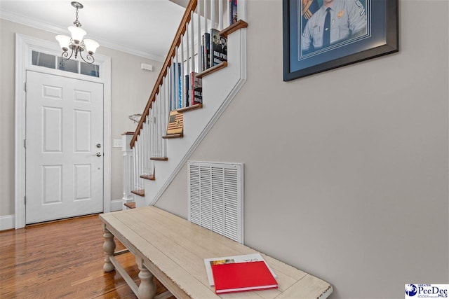 foyer featuring stairway, wood finished floors, visible vents, and crown molding