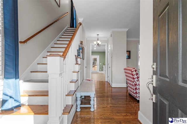 entrance foyer featuring an inviting chandelier, ornamental molding, wood finished floors, baseboards, and stairs