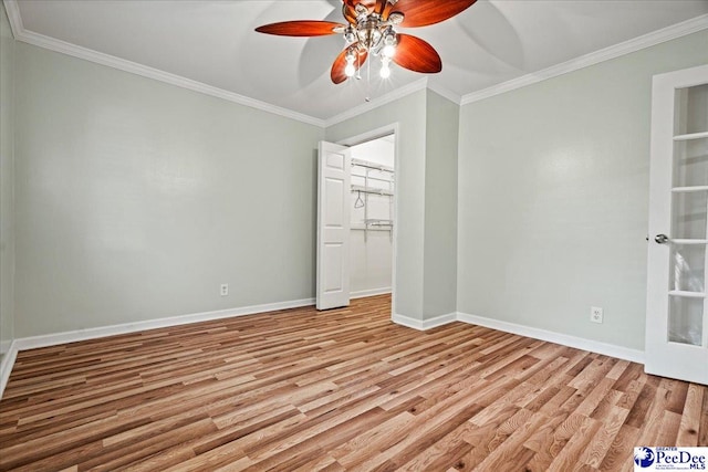 unfurnished bedroom with crown molding, light wood-style flooring, and baseboards