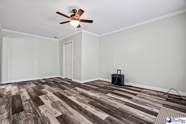 spare room with dark wood-style floors, ornamental molding, and baseboards