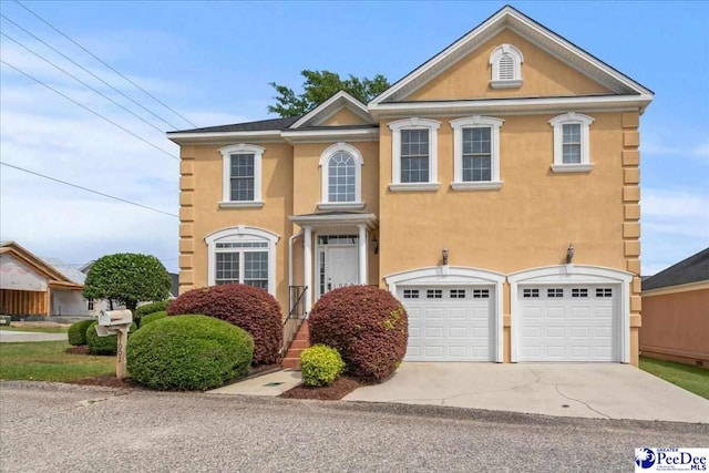 view of front of home with concrete driveway, stucco siding, and an attached garage