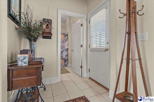 foyer featuring tile patterned flooring and baseboards