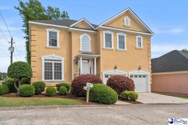 view of front of home with driveway, stucco siding, and a garage