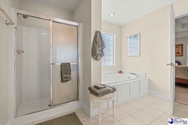 bathroom featuring a stall shower, tile patterned floors, a bath, and baseboards