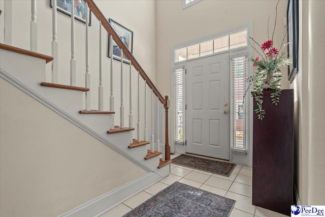 entrance foyer with light tile patterned flooring and stairway
