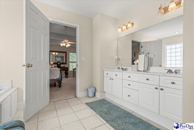 ensuite bathroom featuring double vanity, tile patterned floors, baseboards, and ceiling fan