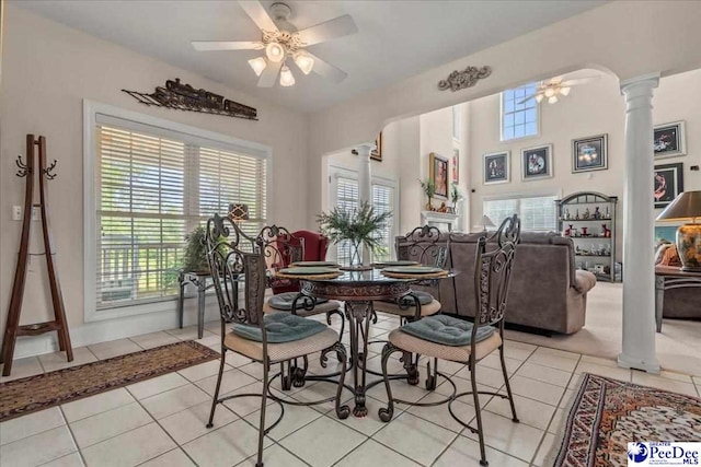 dining area with decorative columns, ceiling fan, and light tile patterned flooring