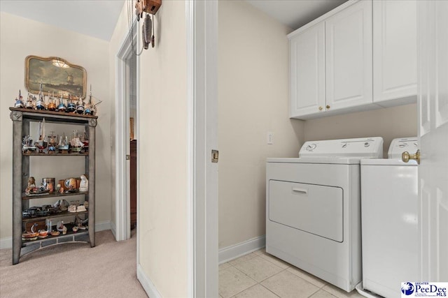 laundry room featuring washer and clothes dryer, cabinet space, and baseboards