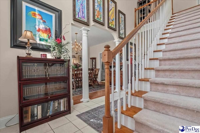 stairway featuring decorative columns, tile patterned flooring, and a high ceiling