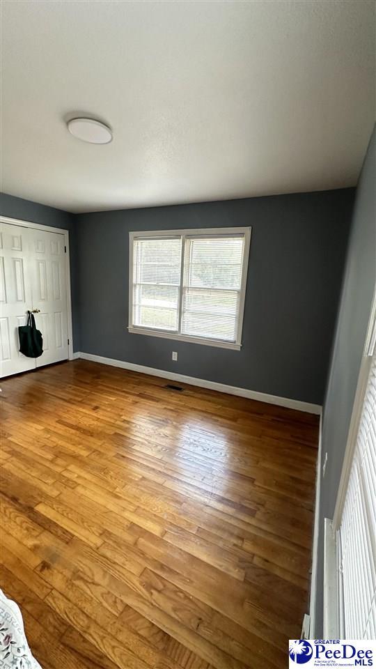 unfurnished bedroom featuring light wood-type flooring and a closet