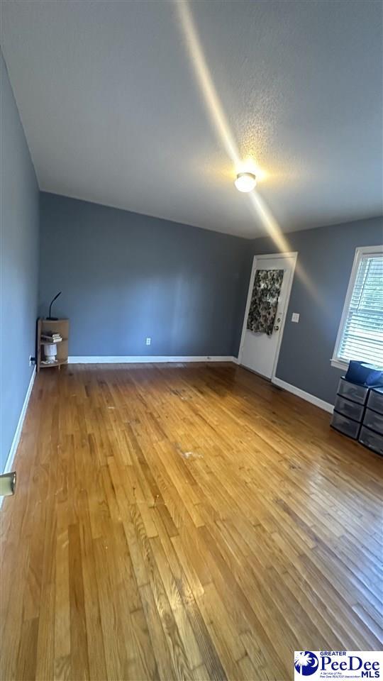 unfurnished living room featuring wood-type flooring and a textured ceiling