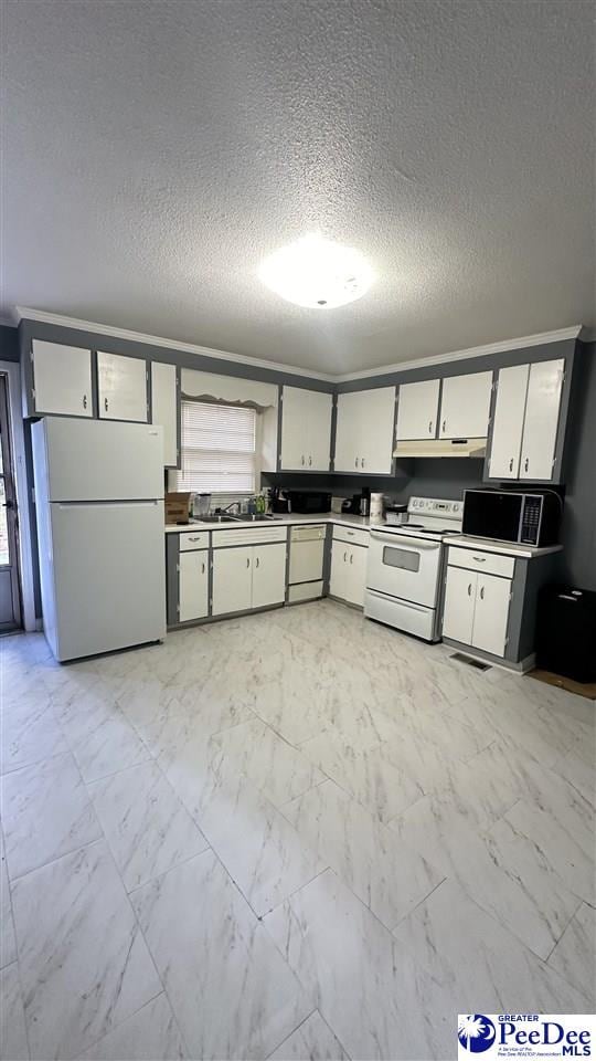 kitchen featuring sink, white appliances, and a textured ceiling